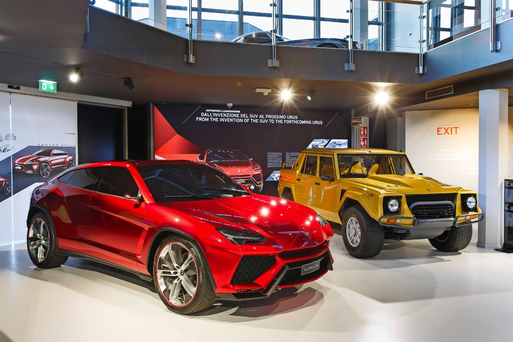 Rote und gelbe Lamborghini-SUVs im Lamborghini-Museum, moderne und klassische Modelle.