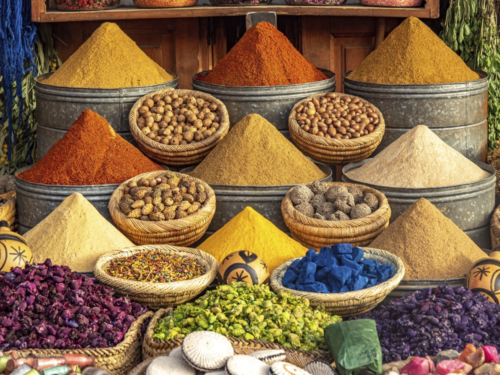 Gewürzstand in Marrakesch mit pyramidenförmig aufgeschichteten Gewürzen, Nüssen und getrockneten Zutaten in verschiedenen Farben